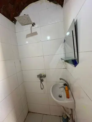 a white bathroom with a sink and a mirror at Nubian King in Aswan
