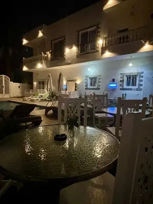 a dining table and chairs in a room with a building at Moon House of Luxor in Luxor