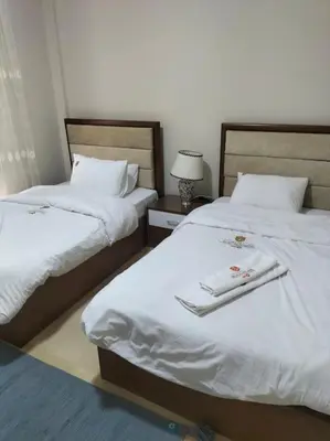 two beds in a hotel room with white sheets at Mangroovy Comfy 2 Bedroom in Hurghada