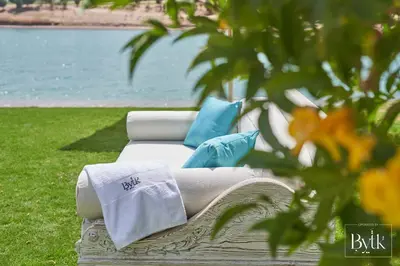 a white couch with blue pillows sitting in the grass at BYTK - La Galería in Hurghada