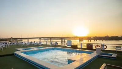 a pool on a cruise ship with a bridge in the background at Cleopatra Nile Cruise in Luxor