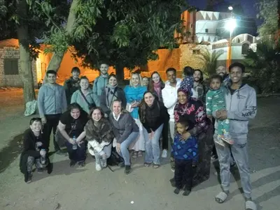 a group of people posing for a picture at night at Sabaha Kato in Aswan