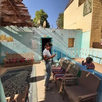 a woman looking at her cell phone in front of a building at Sabaha Kato in Aswan