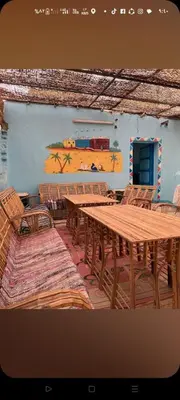 a wooden table and chairs with a train on the wall at Sabaha Kato in Aswan