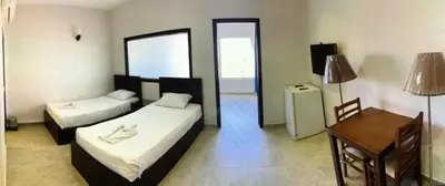 a room with two beds and a table and a desk at Family Suite in view aqua mirage bay in Hurghada