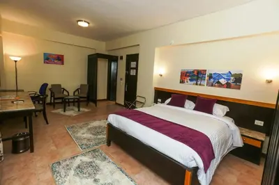 a hotel room with a bed and a table and chairs at Jawhara Inn Hotel - فندق الجوهرة سفاجا in Hurghada