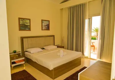 a bedroom with a bed and a large window at Stylish 4BR Villa V15 with a Private Heated Pool at White Villas in Hurghada