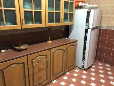 a kitchen with wooden cabinets and a refrigerator at Sea view apartment in Hurghada