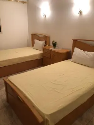 a room with two beds and a night stand with two beds at Sea view apartment in Hurghada