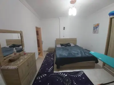 a bedroom with two beds and a mirror at شقة ٢ غرفة in Hurghada