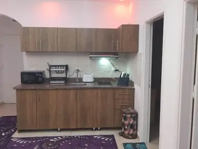 a kitchen with a counter with a sink and a microwave at شقة ٢ غرفة in Hurghada