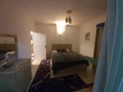 a bedroom with a bed and a bathroom with a sink at شقة ٢ غرفة in Hurghada