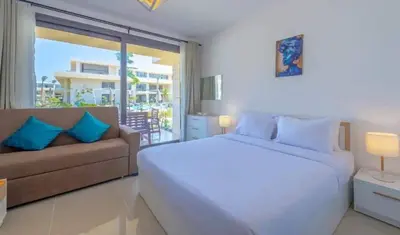 a bedroom with a white bed and a couch at Ground Floor Studio - G Cribs -Elgouna in Hurghada