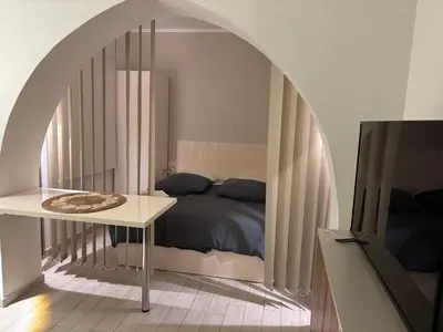 a bedroom with a bed under an archway with a table at Stay in the center of Elgouna in Hurghada