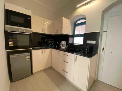 a kitchen with white cabinets and black counter tops at Stay in the center of Elgouna in Hurghada