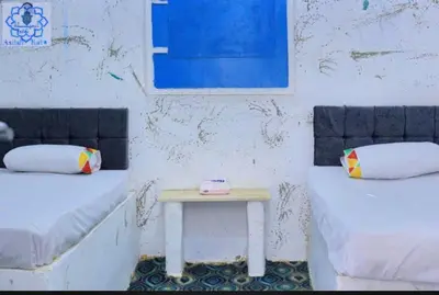 a room with two beds and a small table at Asilah kato nubian guest house in Aswan