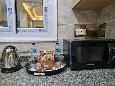 a kitchen counter with a microwave and a basket of food at Hurghada Appartment front of dream beach in Hurghada