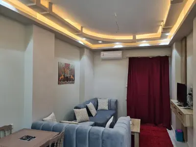 a living room with a blue couch and a red rug at Hurghada Appartment front of dream beach in Hurghada
