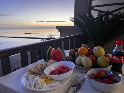 a plate of food on a table with a view of the ocean at My Sky Sea View 1 Bedroom Apartment in Hurghada