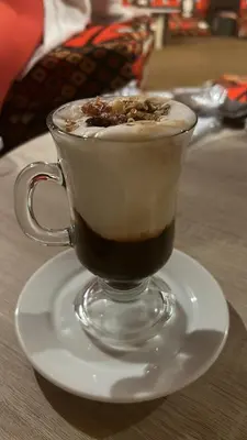 a cup of coffee on a plate on a table at My Sky Sea View 1 Bedroom Apartment in Hurghada