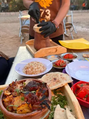 a person wearing black gloves standing at a table with food at My Sky Sea View 1 Bedroom Apartment in Hurghada
