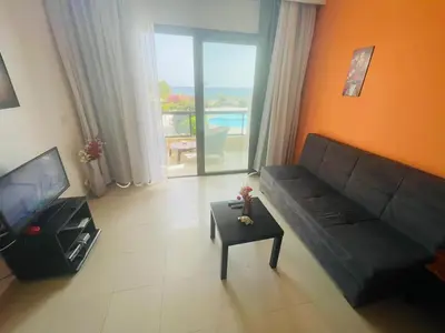 a living room with a couch and a television at Navy Chalet 108 in Hurghada