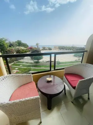 a balcony with two chairs and a table and a window at Navy Chalets 107 in Hurghada