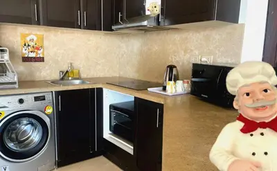 a statue of a chef in a kitchen next to a washing machine at Apartment Azzura Sahl Hasheesh with private garden in Hurghada
