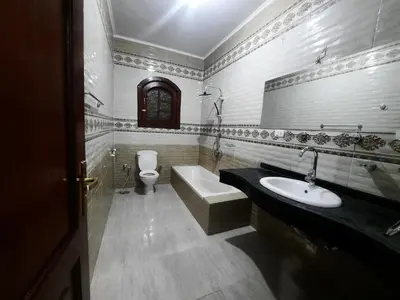 a bathroom with a sink and a tub and a toilet at The royal flat for rent in Al Qurnah
