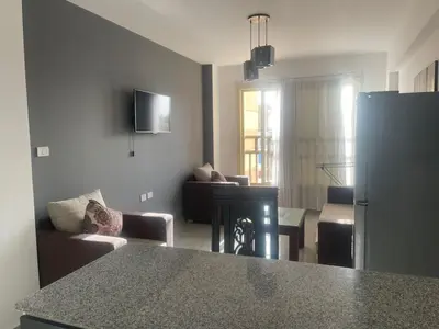 a kitchen and living room with a refrigerator and a couch at Marina City portghalib one bedroom in Port Ghalib