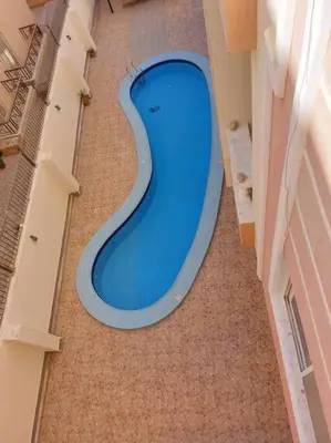 a blue swimming pool in the middle of a building at Nice Studio in Elegant Compound Intercontinental Area in Hurghada