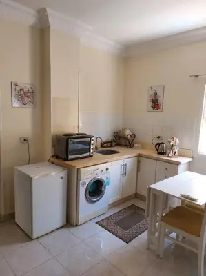 a kitchen with a washing machine and a microwave at Nice Studio in Elegant Compound Intercontinental Area in Hurghada