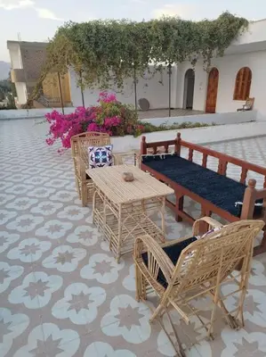 a patio with a table and chairs and a bench at Gabawy Garden Doppelzimmer in Luxor