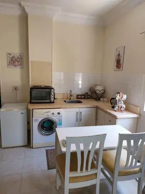 a kitchen with a washing machine and a table and chairs at Cozy/Comfy Studio at Intercontinental Area in Hurghada