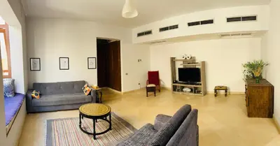a living room with a couch and a tv at CozY Condo in Hurghada