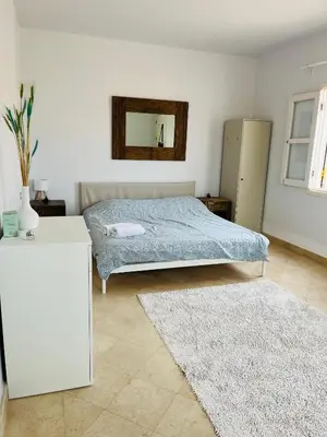 a bedroom with a bed and a mirror and two rugs at CozY Condo in Hurghada