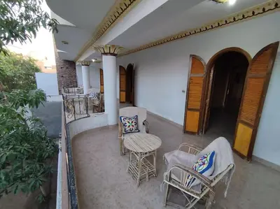 an outdoor patio with chairs and a table and chairs at Gabawy Garden, Privatzimmer mit zwei Einzelbetten in Luxor