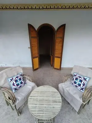 a living room with two chairs and a table at Gabawy Garden, Privatzimmer mit zwei Einzelbetten in Luxor