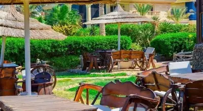 an outdoor restaurant with tables and chairs and umbrellas at Palma Resort in Hurghada