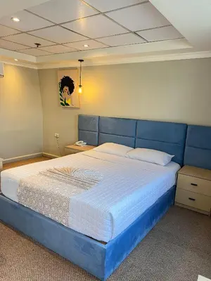 a bed with a blue headboard in a bedroom at Luxor Aswan Coral 2 Nile Cruise every Saturday from Luxor 4 nights & every Wednesday from Aswan 3 nights in Luxor